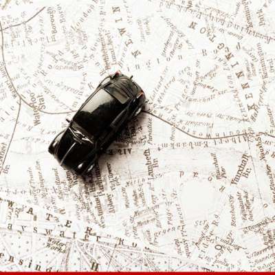 Carrinho de brinquedo preto sobre um mapa desbotado de Londres, Inglaterra.