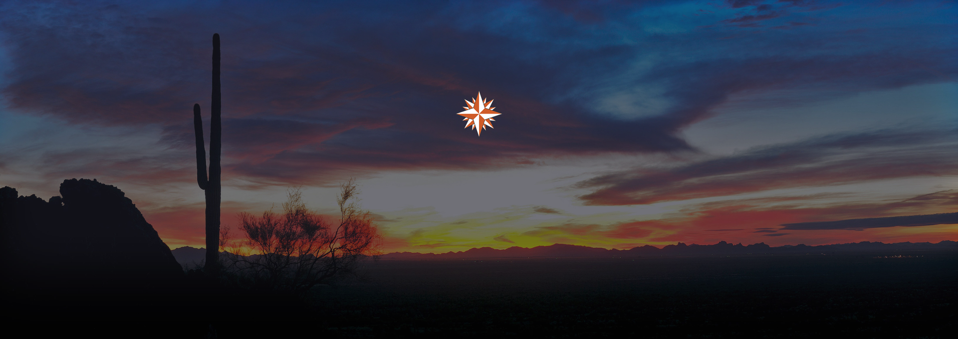 Sunset sky over a silhouetted cactus and desert landscape, with a glowing star-like light in the center