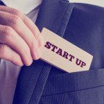 Businessman removing a wooden card reading Start up from his poc