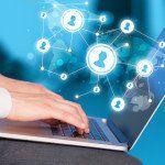 Close up of hand with laptop and social media icons