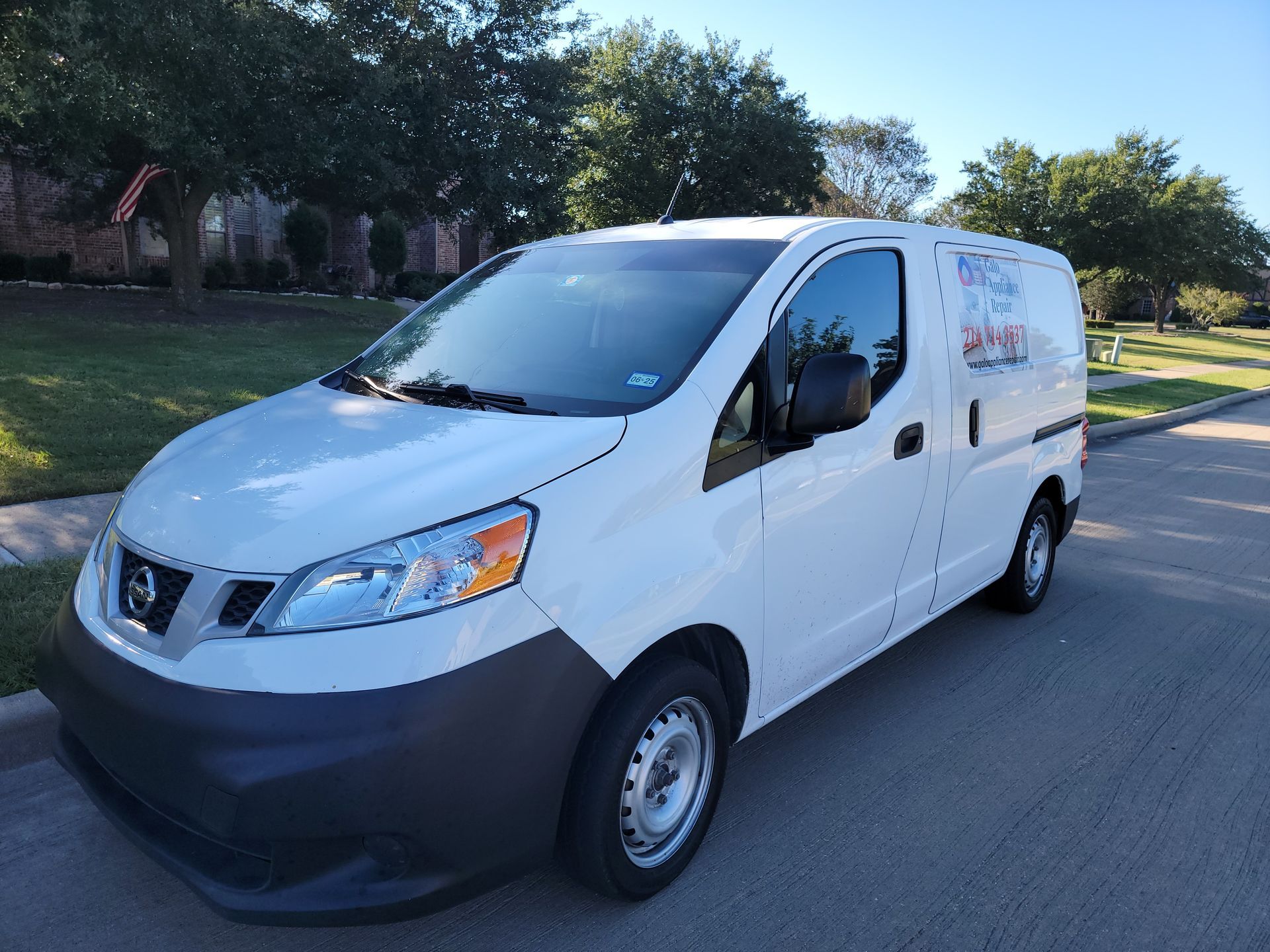 A white van is parked on the side of the road.