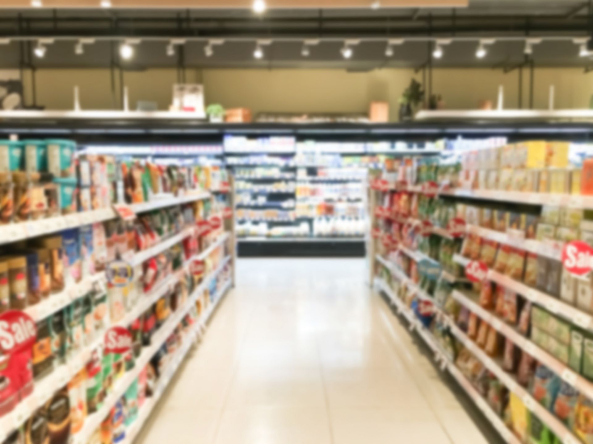 雜貨店貨架上擺滿各種商品的模糊圖​​像。
