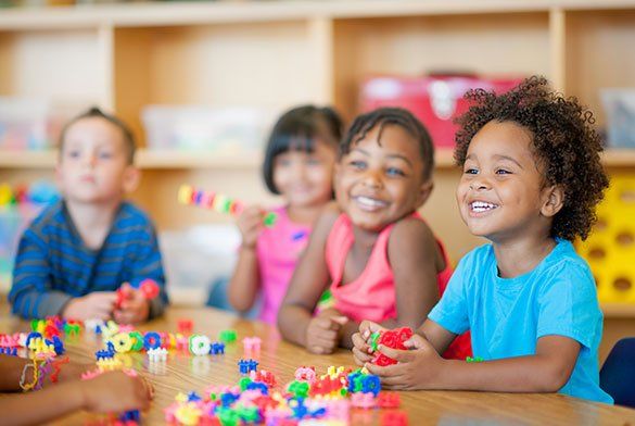 Kids Smiling With Their Toys — Tuscaloosa, AL — Tender Loving Care Kids Smiling With Their Toys — Tuscaloosa, AL — Tender Loving Care