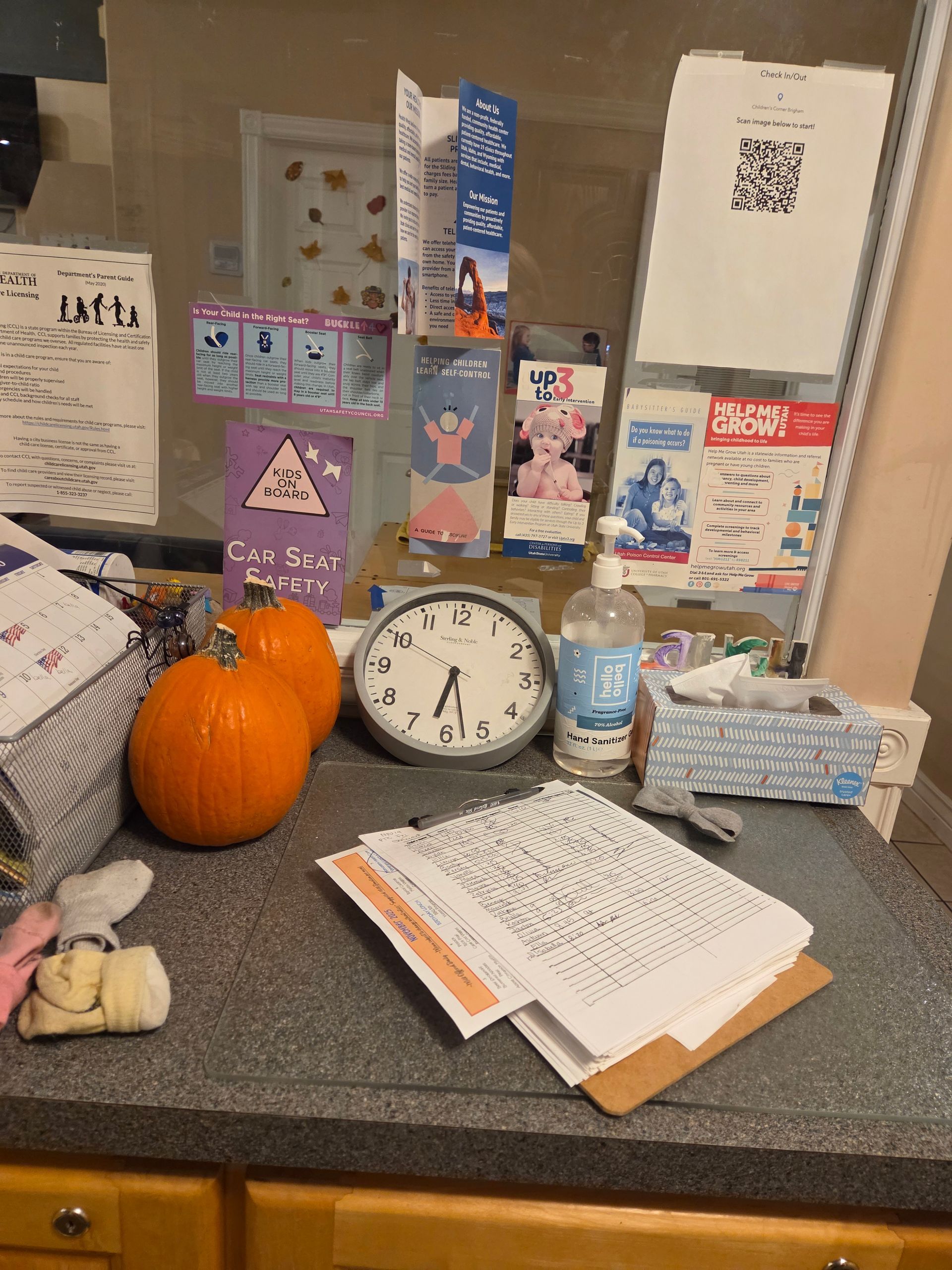 Halloween-decorated tabletop with pumpkins, clock, candy boxes, and a bottle of water
