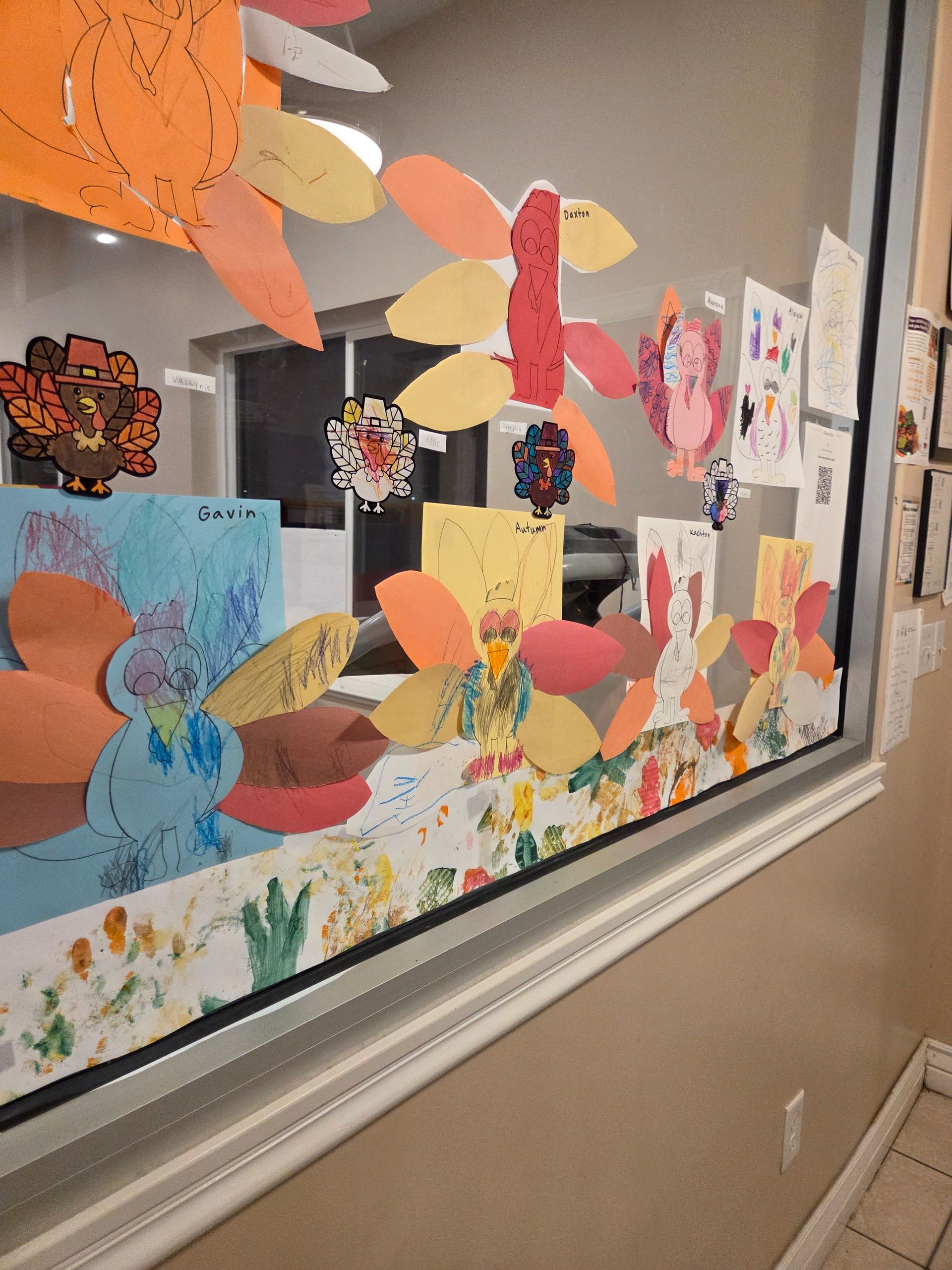 Colorful butterfly and flower paper crafts displayed on a classroom window panel