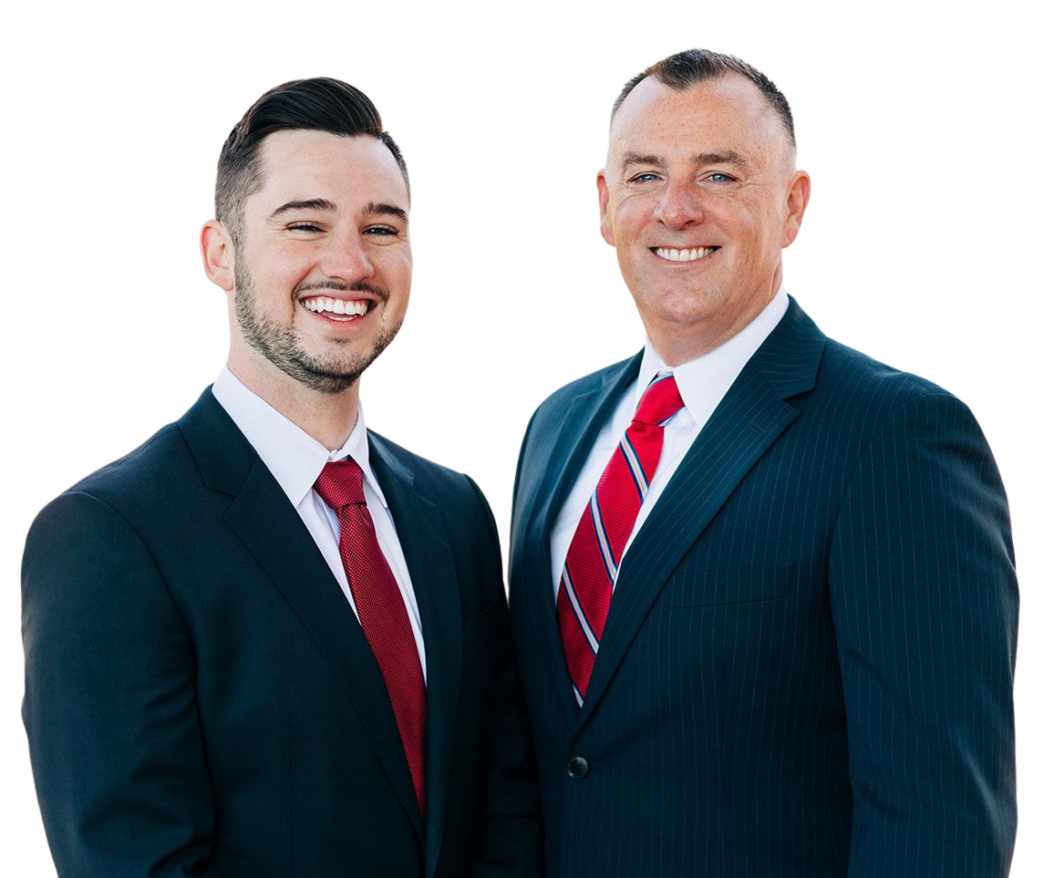 Two men in dark suits and red ties smiling against a white background