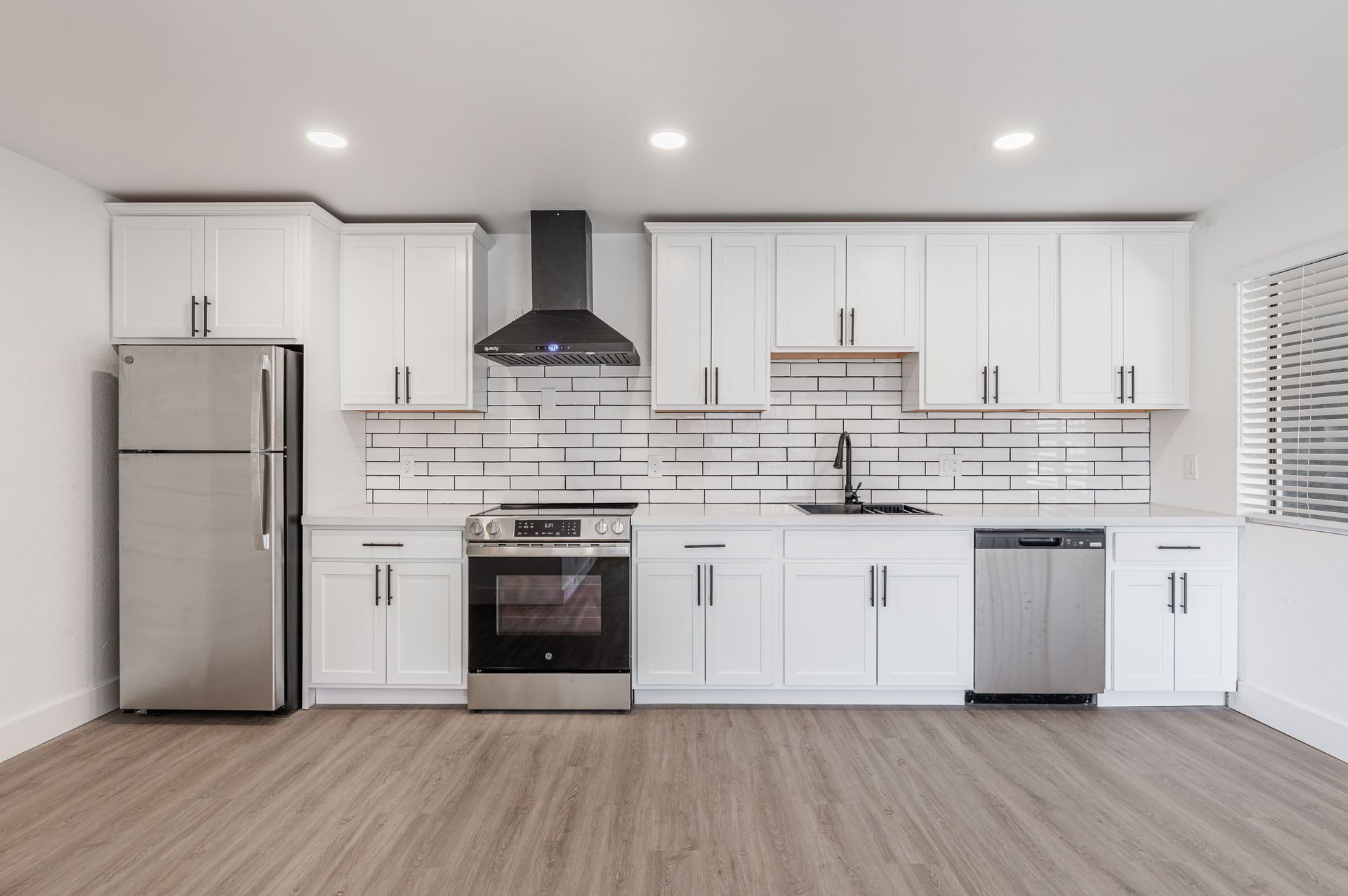Kitchen with dark countertops, stainless steel appliances, and reddish-brown cabinets.
