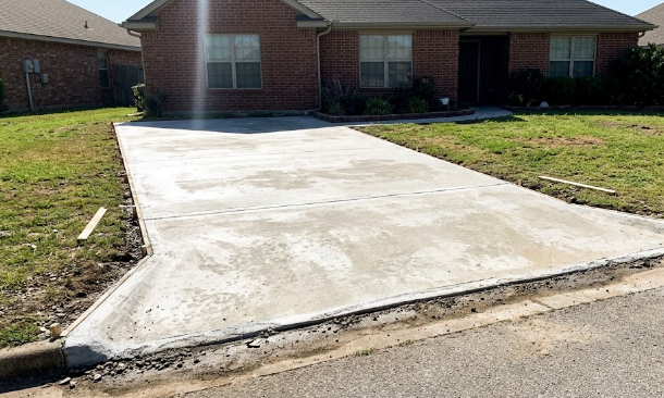 Durable, freshly poured concrete driveway installed for a home by local concrete contractors.