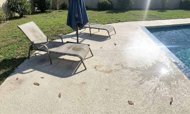 Safe, slip-resistant concrete pool deck surrounding a backyard swimming pool.