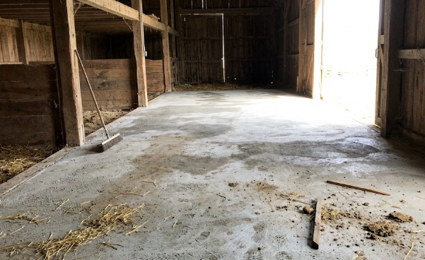 Freshly poured and textured concrete barn floor inside a modern agricultural building.