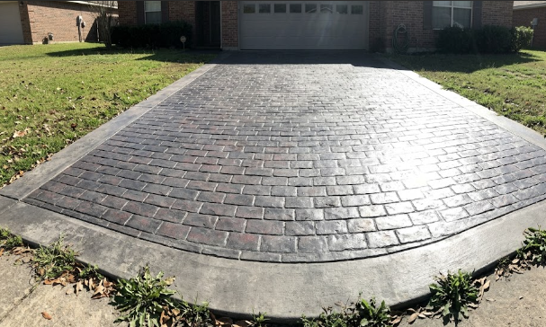 A durable decorative concrete driveway stamped with a cobblestone pattern for a local home.