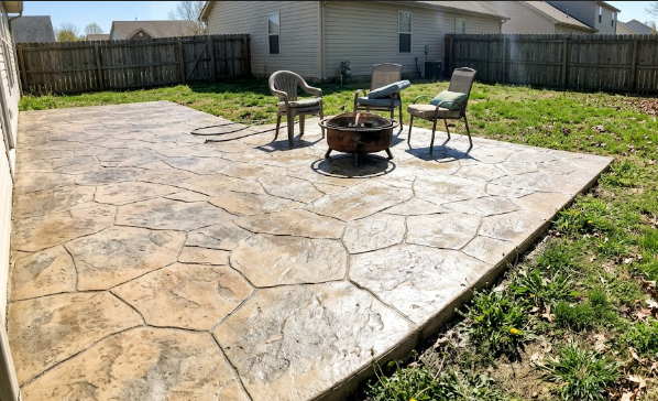 A beautiful stamped concrete patio in Frederick MD resembling natural flagstone with outdoor furniture.