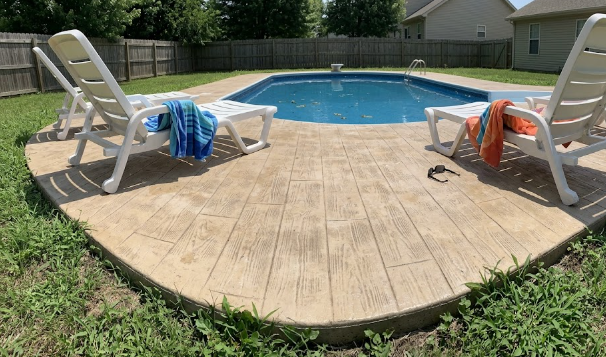 A safe, slip-resistant decorative concrete pool deck with a wood plank stamp design.