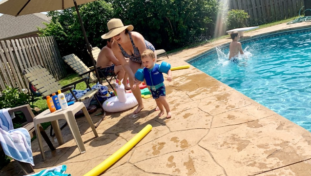 A textured, slip-resistant stamped concrete pool deck in a sunny backyard.