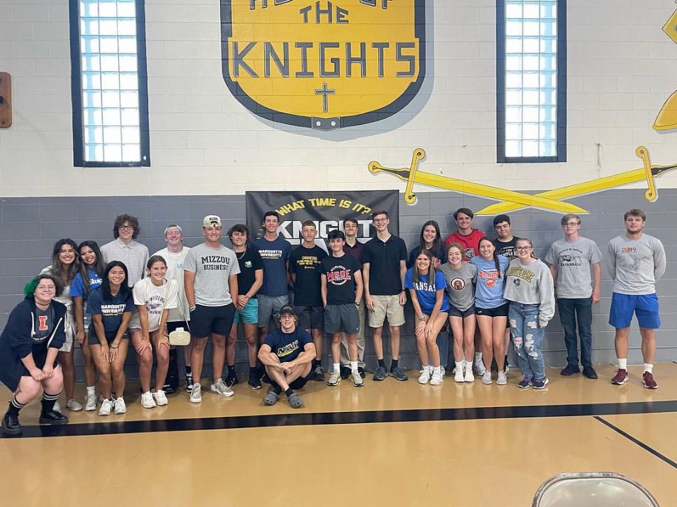 A group of people are posing for a picture in a gym.