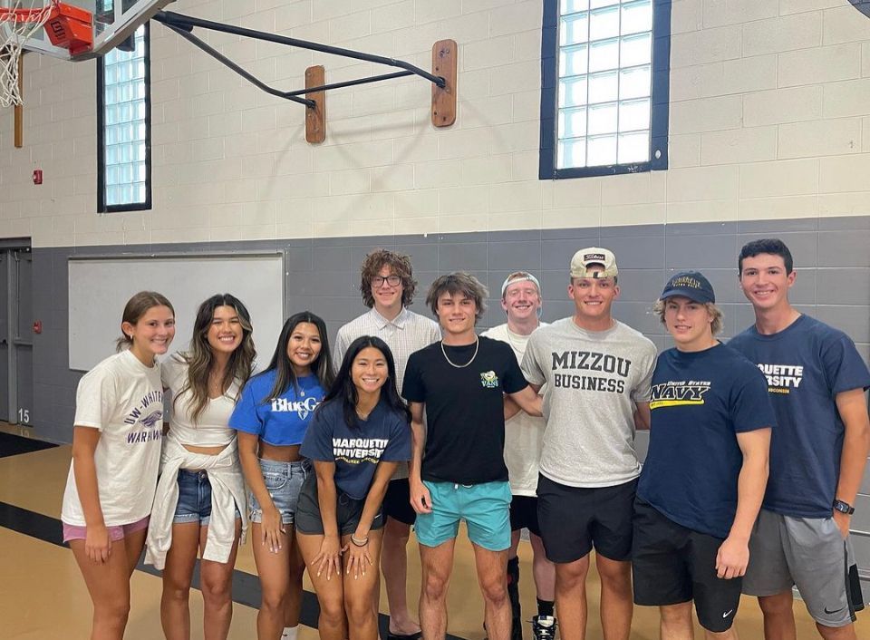 A group of young people are posing for a picture in a gym.