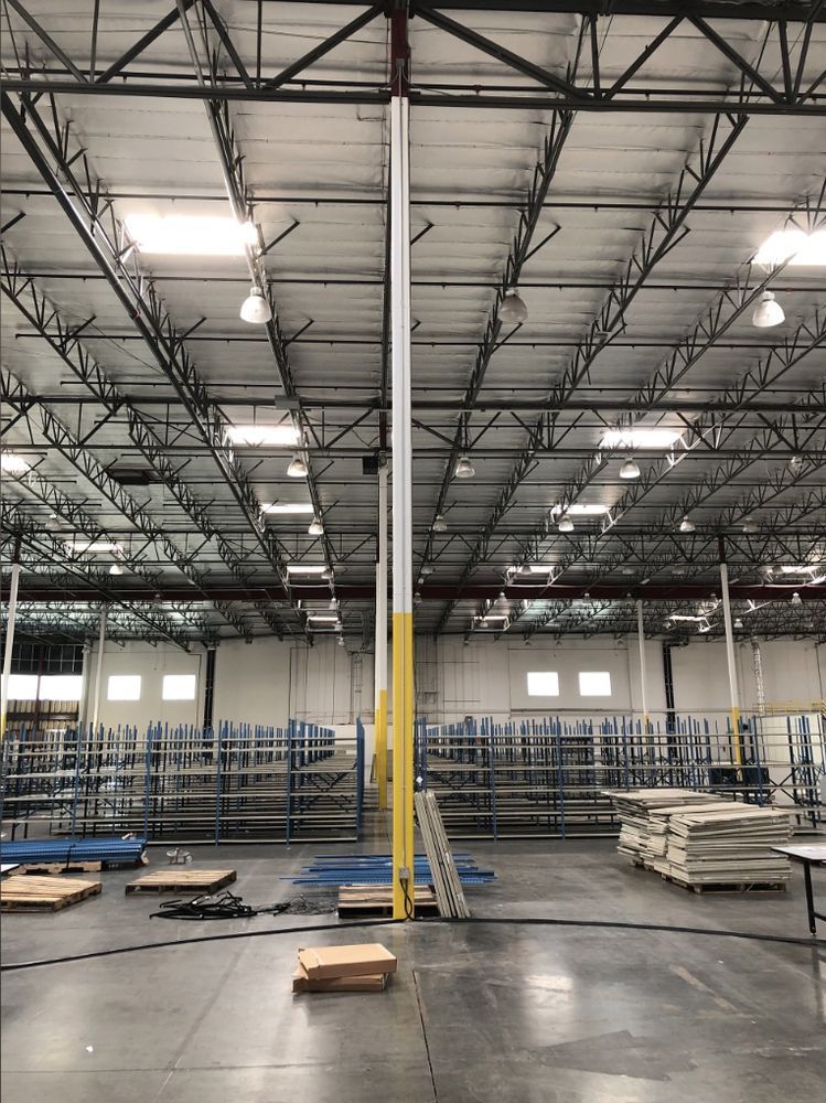 A large warehouse with lots of shelves and a ladder