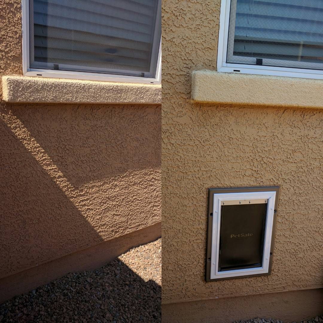 Exterior wall of a beige stucco house with two windows and a small pet door near the ground