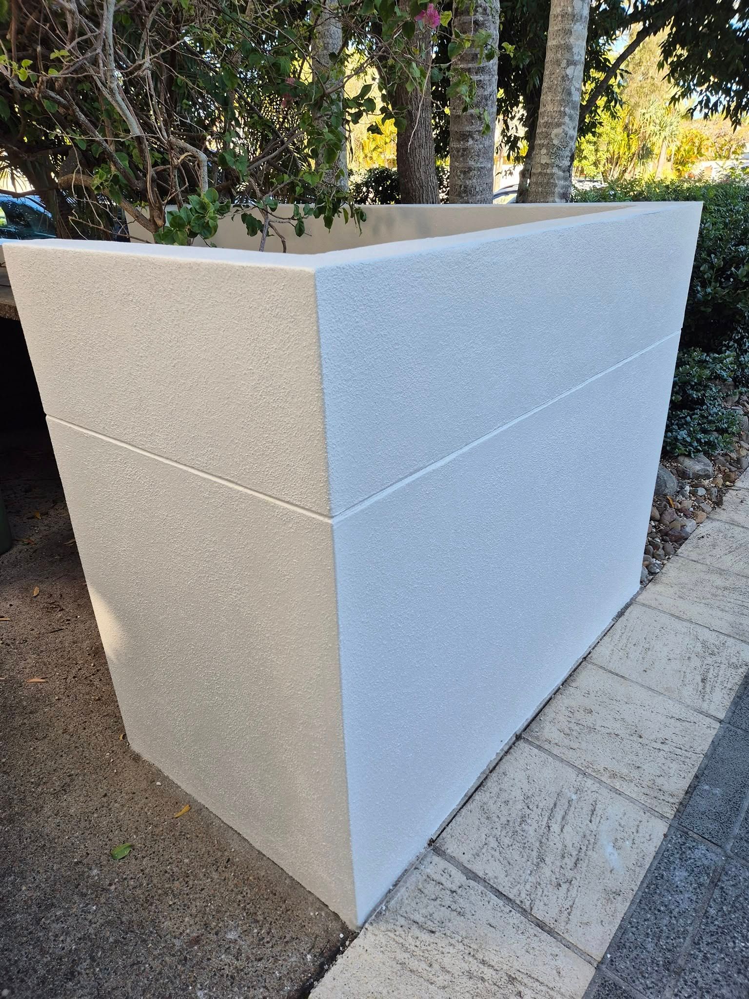Gray concrete planter box on a paved path, with vegetation in the background. — MJ Render in Buderim, QLD