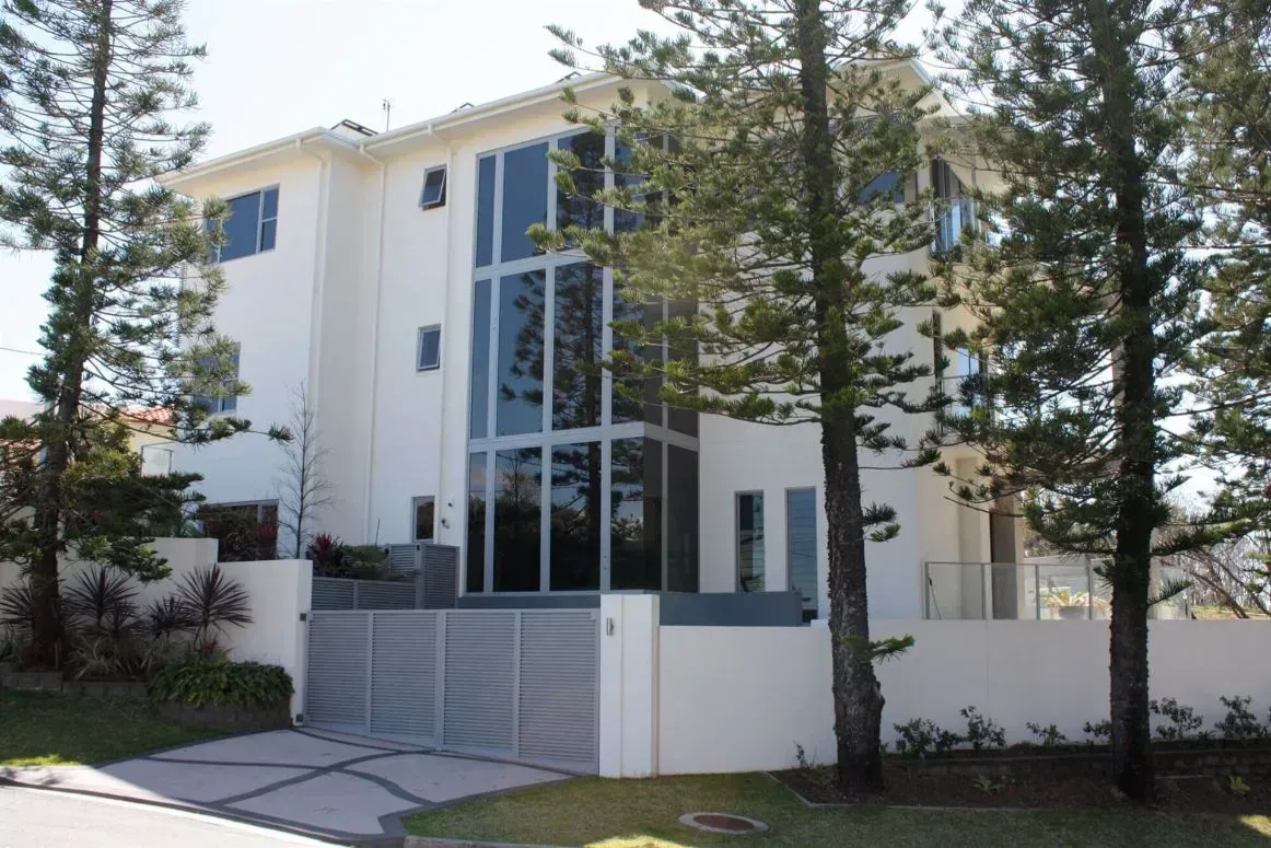 A Large White House with Lots of Windows Is Surrounded by Trees  — MJ Render in Buderim, QLD