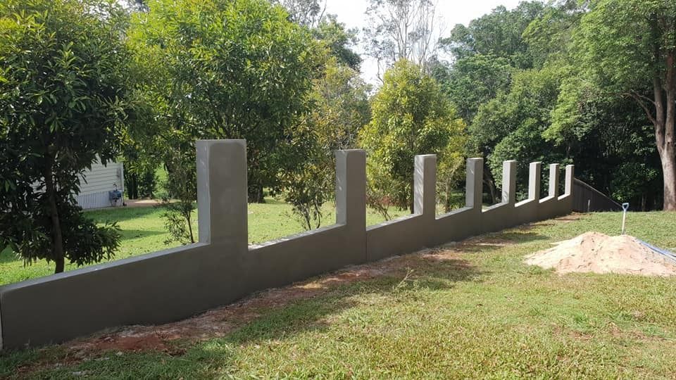 A Concrete Fence Is Sitting in The Middle of A Lush Green Field — MJ Render in Buderim, QLD
