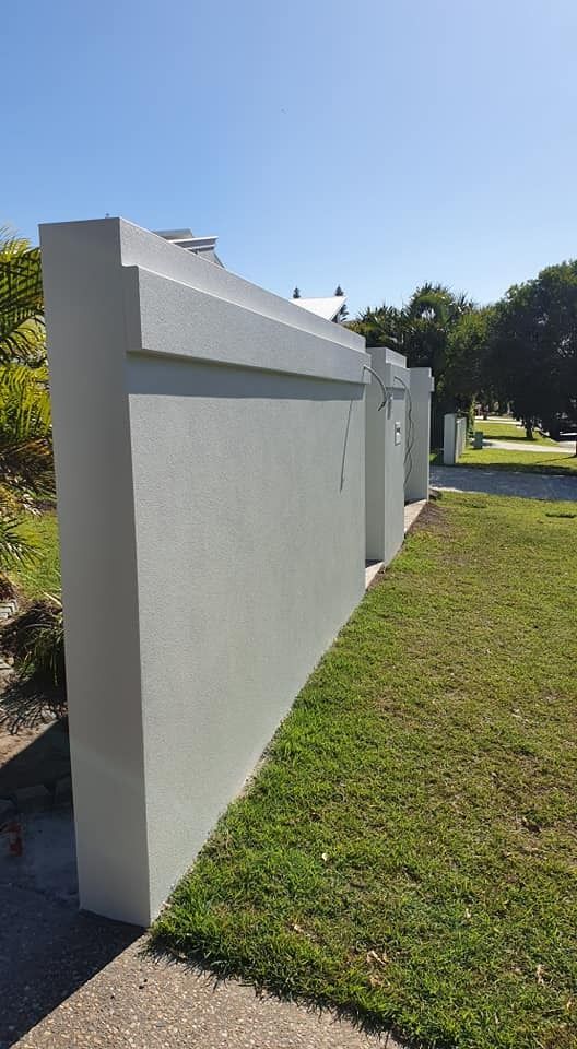A Large White Wall Is Sitting Next to A Lush Green Field — MJ Render in Buderim, QLD