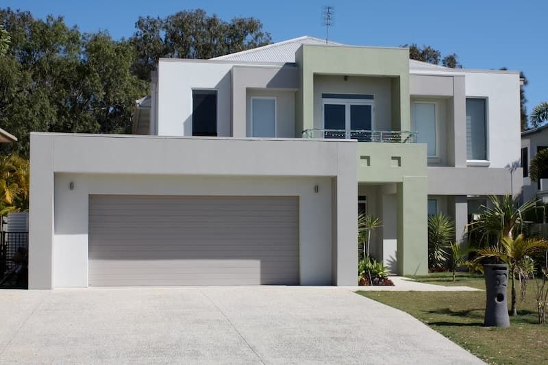 A Large White House with A Gray Garage Door — MJ Render in Buderim, QLD
