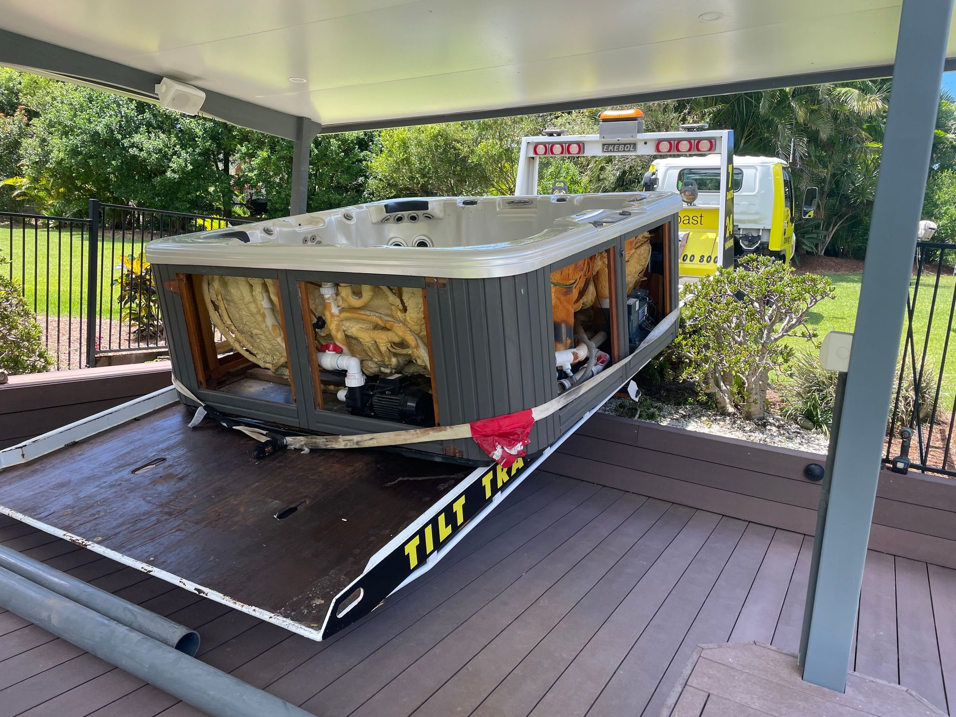 A Yellow Til Towing truck park in carrying a spa