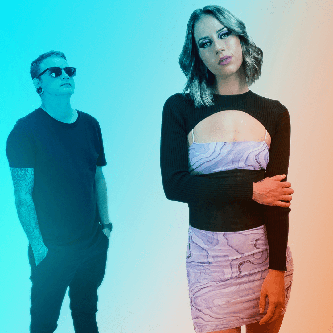 A man in sunglasses stands behind a woman wearing a black long-sleeved cutout top and purple patterned skirt against a fade.
