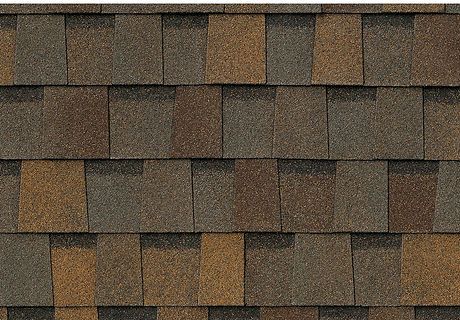 Close-up of weathered brown and gray roof shingles with a layered pattern