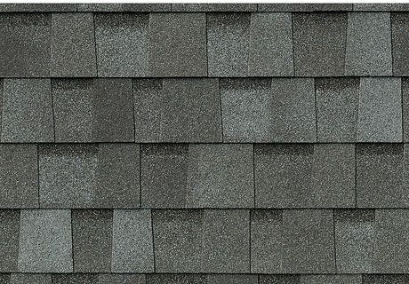 Close-up of gray asphalt roof shingles in a repeating pattern
