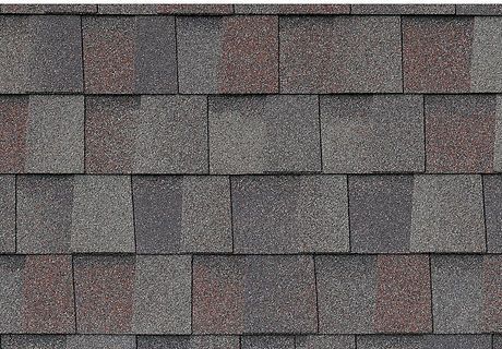 Close-up of gray and reddish-brown roof shingles in a repeating pattern