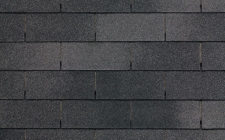 A close up of a row of black shingles on a roof.
