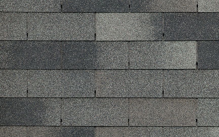 A close up of a row of gray shingles on a roof.