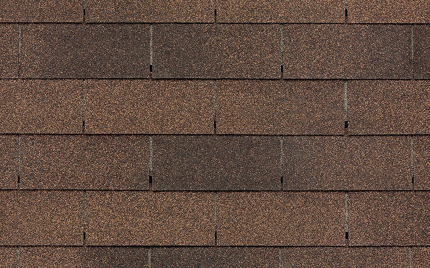 A close up of a row of brown shingles on a roof.
