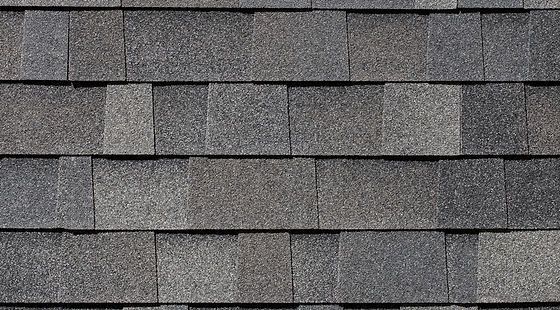 A close up of a row of gray shingles on a roof.