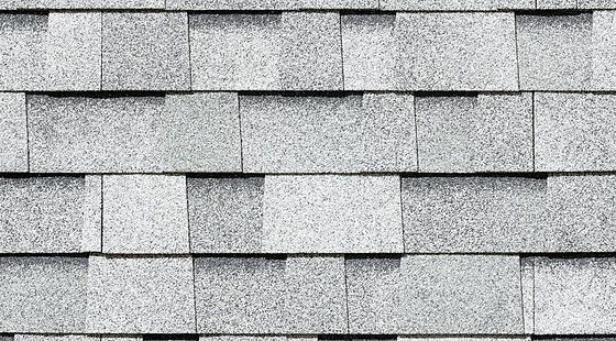 A close up of a row of gray tiles on a roof.