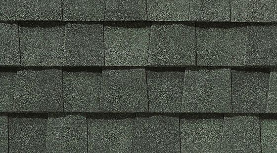 Close-up of dark gray asphalt roof shingles in a staggered pattern