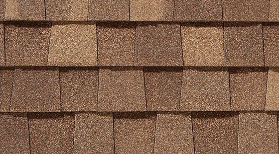 Brown asphalt roof shingles in a close-up pattern