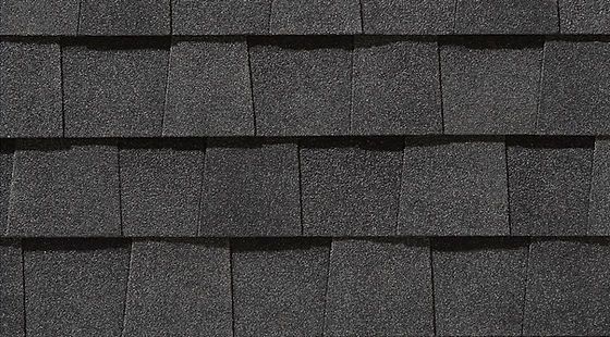 Close-up of dark gray asphalt roof shingles arranged in horizontal rows.