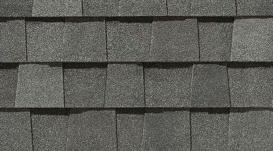 Gray asphalt roof shingles in a repeating staggered pattern.