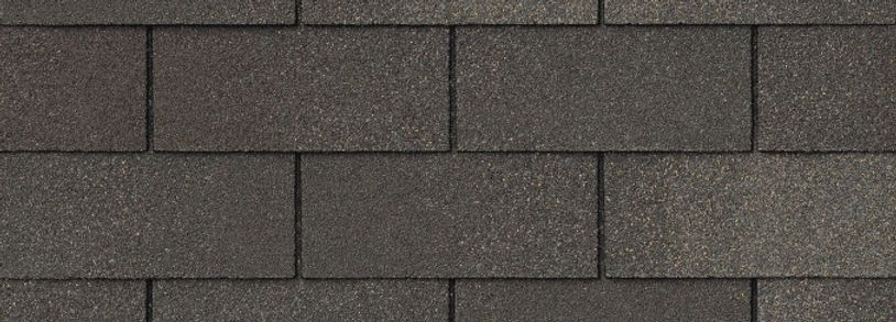 Close-up of dark gray asphalt roof shingles arranged in staggered rows.