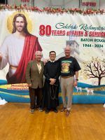 Three people posing before a church banner reading “80 Years of Faith & Service” at Baton Rouge 2024-2025.