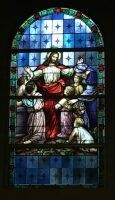 Stained glass of Jesus with children, in blue and red tones, inside a church window