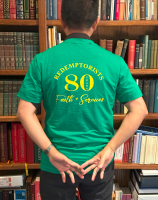 Person facing bookshelf, wearing green shirt with yellow text and number 80, hands behind back.