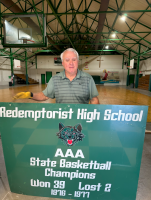 Man holding banner for Redemptorist High School 1969 state basketball champions in a gymnasium
