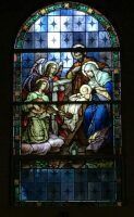 Stained-glass window of a religious scene with several figures in blue, red, and white robes