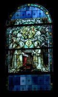 Stained-glass window with religious figures in blue, green, and red tones