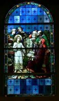 Stained-glass window of a robed white figure with a group of people against a blue patterned background