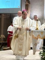 Priest in cream vestments walking at church altar during a service